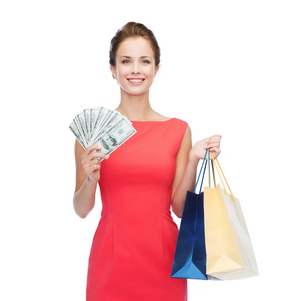Lächelnde elegante Frau im Kleid mit Einkaufstaschen — Stockfoto