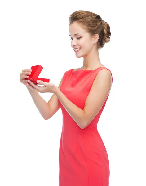 Jeune femme souriante en robe rouge avec boîte cadeau — Photo