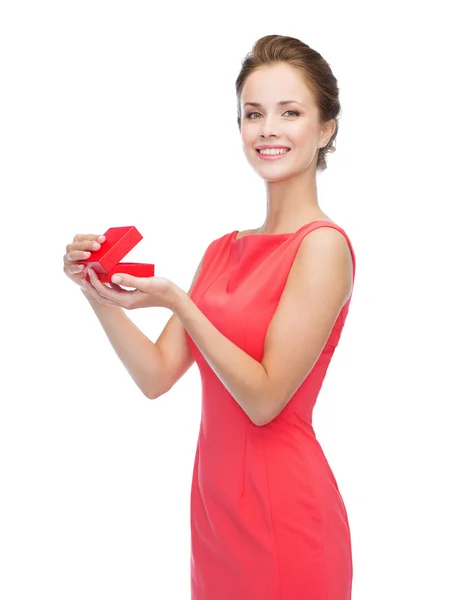 Lächelnde junge Frau in rotem Kleid mit Geschenkbox — Stockfoto