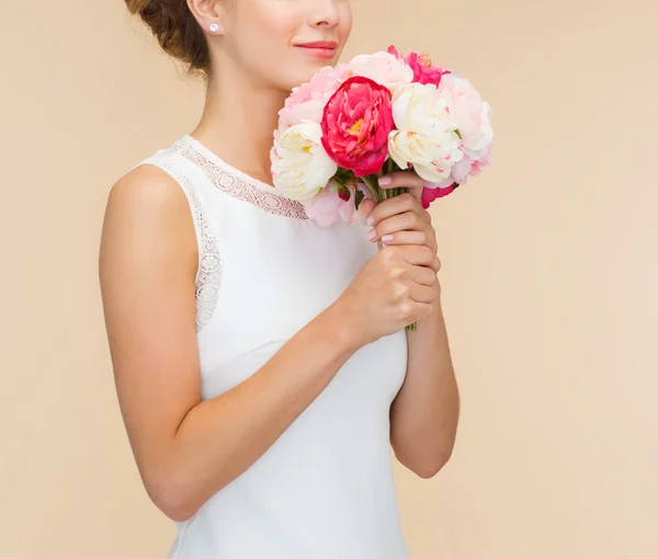 Smiling woman in white dress with bouquet of roses — Stock Photo, Image