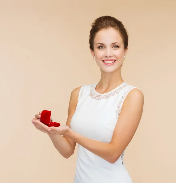 Sonriente mujer sosteniendo caja de regalo roja con anillo —  Fotos de Stock