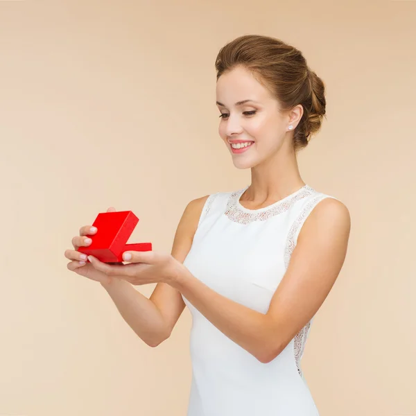 Smiling woman holding red gift box — Stock Photo, Image