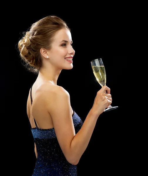 Sonriente mujer sosteniendo un vaso de vino espumoso — Foto de Stock