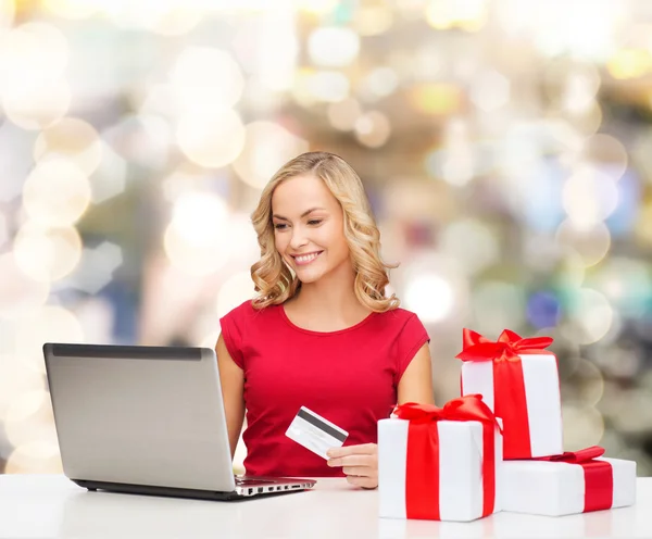 Lächelnde Frau mit Kreditkarte und Laptop lizenzfreie Stockfotos