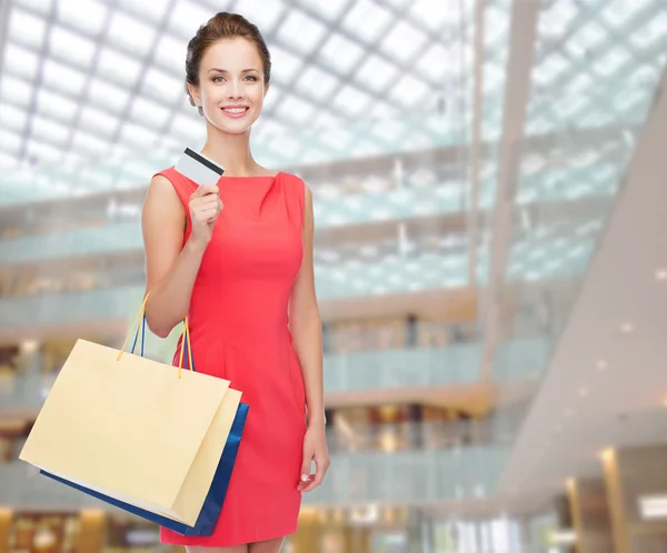 Усміхнена жінка з сумками і пластиковою карткою — стокове фото