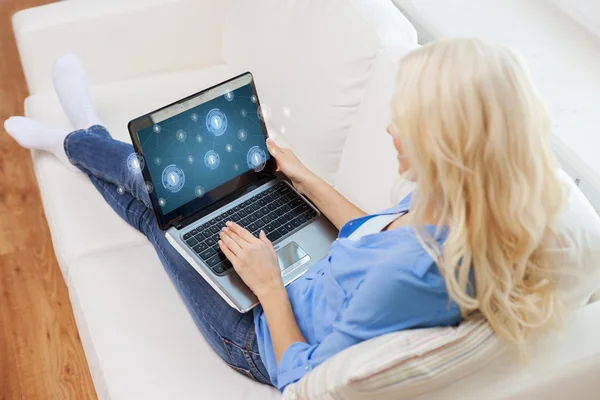 Mulher sorridente com computador portátil em casa — Fotografia de Stock