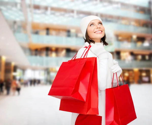 赤いショッピング バッグを持つ若い女性の笑みを浮かべてください。 — ストック写真