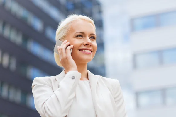 Glimlachende zakenvrouw met smartphone outdoors — Stockfoto