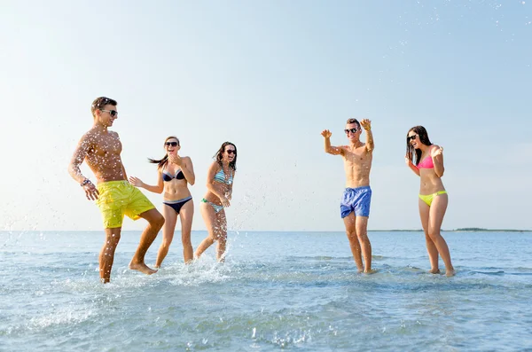 Счастливые друзья, веселящиеся на летнем пляже — стоковое фото
