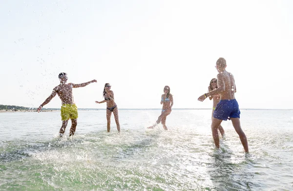 Amigos felices divirtiéndose en la playa de verano — Foto de Stock