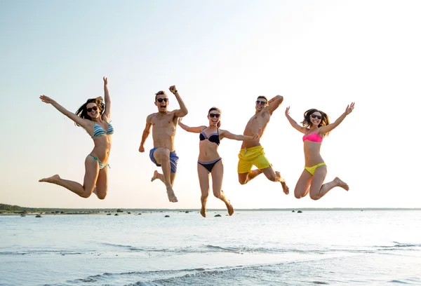 Lächelnde Freunde mit Sonnenbrille am Sommerstrand — Stockfoto