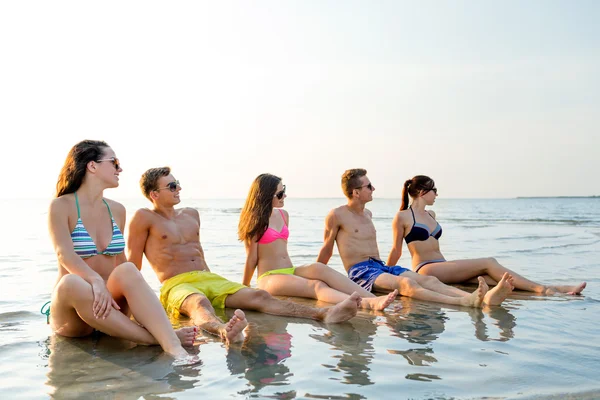 Amigos sonrientes en gafas de sol en la playa de verano — Foto de Stock