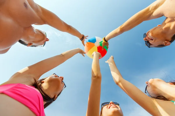 Lächelnde Freunde im Kreis am Sommerstrand — Stockfoto