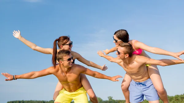 Amigos sonrientes divirtiéndose en la playa de verano — Foto de Stock