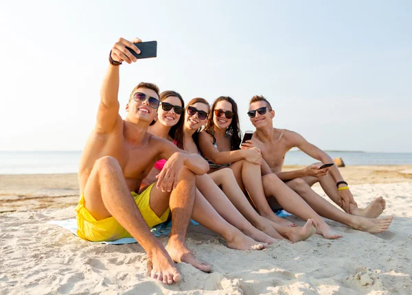 Amis avec smartphones sur la plage — Photo