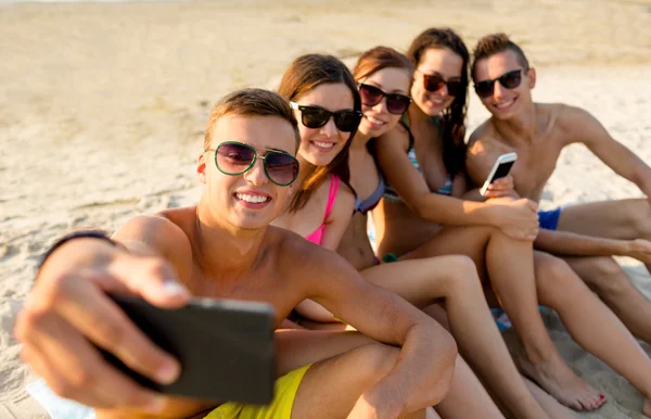 Amis avec smartphones sur la plage — Photo