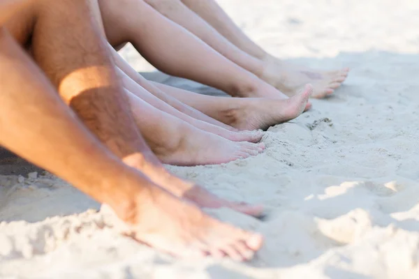 Close up van vrienden zittend op zomer strand — Stockfoto