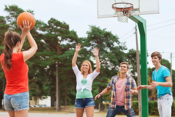 Group of smiling teenagers playing basketball — Stock Photo, Image