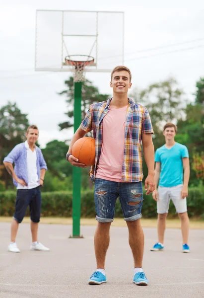 Group of smiling teenagers playing basketball — Stock Photo, Image