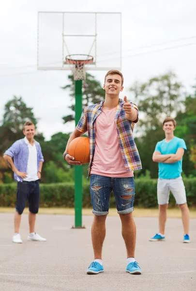 Groep van lachende tieners spelen basketbal — Stockfoto