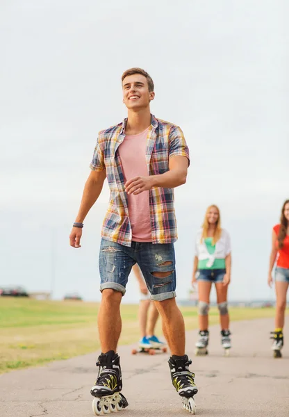 Grupp leende tonåringar med roller-skates — Stockfoto