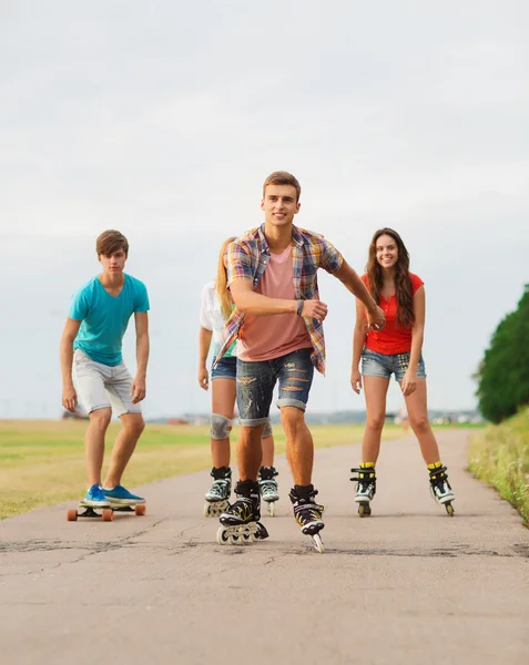 Grupp leende tonåringar med roller-skates — Stockfoto