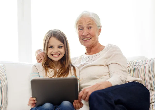 Familie zâmbitoare cu tabletă PC acasă — Fotografie, imagine de stoc