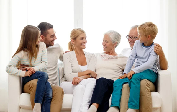 Família feliz sentada no sofá em casa — Fotografia de Stock