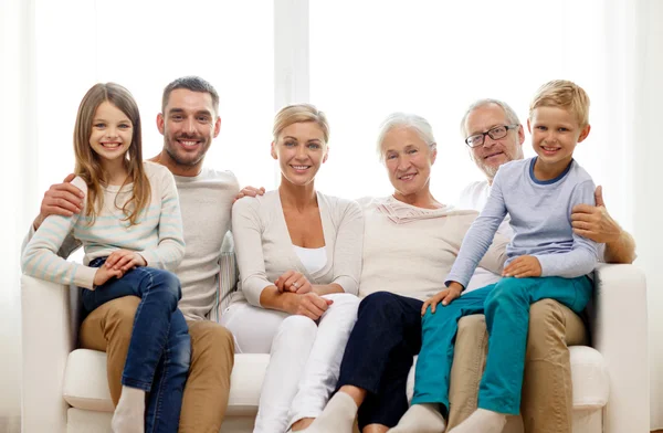 Happy family sitting on couch at home — Stock Photo, Image