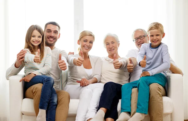 Família feliz sentada no sofá em casa — Fotografia de Stock