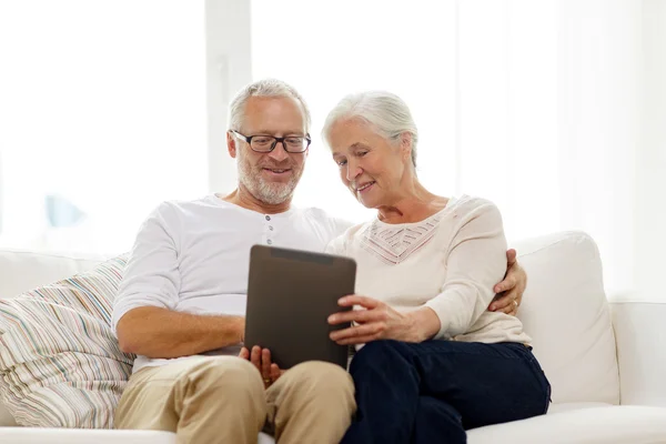 Feliz casal sênior com tablet pc em casa — Fotografia de Stock