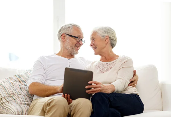Felice coppia anziana con tablet pc a casa — Foto Stock