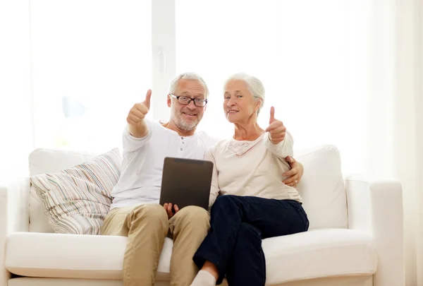 Glückliches Seniorenpaar mit Tablet-PC zu Hause — Stockfoto