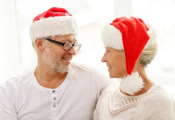 Šťastný starší pár v santa čepice pomocník doma — Stock fotografie