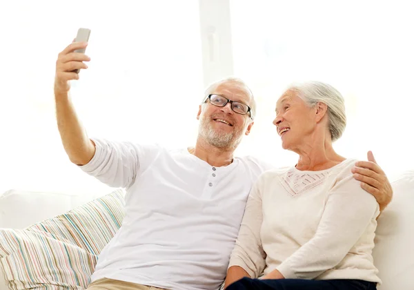 Happy senior couple with smartphone at home — Stock Photo, Image