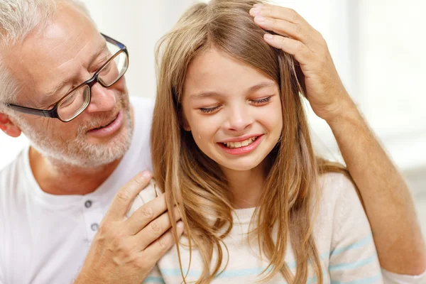 Grandfather with crying granddaughter at home — Stock Photo, Image