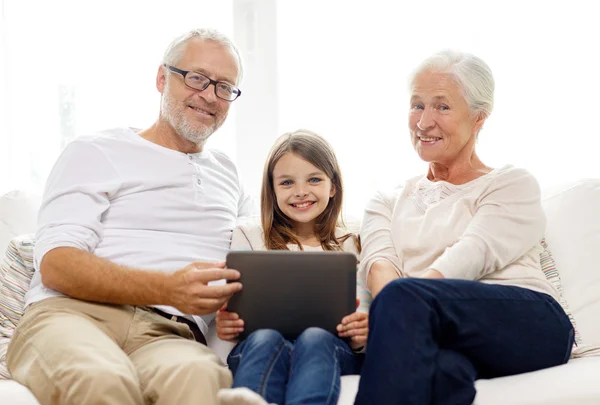 Familia sonriente con tablet pc en casa —  Fotos de Stock