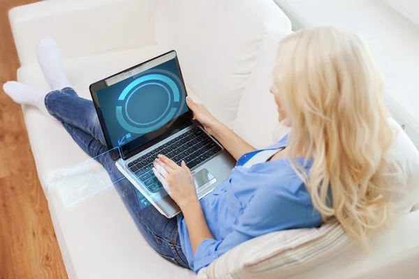 Mulher sorridente com computador portátil em casa — Fotografia de Stock