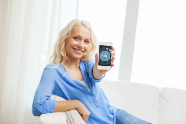 Smiling woman with smartphone at home — Stock Photo, Image