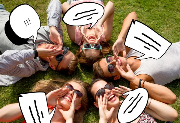 Группа улыбающихся друзей, лежащих на траве — стоковое фото