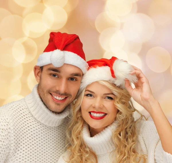 Lächelndes Paar in Pullovern und Weihnachtsmann-Helfermützen — Stockfoto