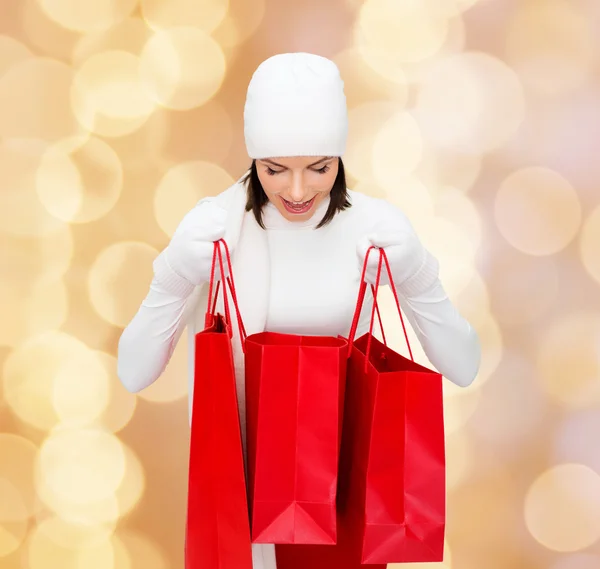 Sorrindo jovem mulher com sacos de compras vermelhos — Fotografia de Stock