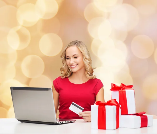 Smiling woman with credit card and laptop — Stock Photo, Image