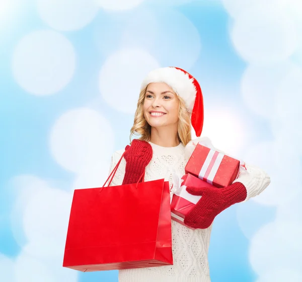 微笑在圣诞老人的助手帽子与礼品的年轻女子 — 图库照片