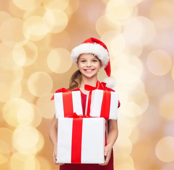 Sorrindo menina em santa chapéu ajudante com presentes — Fotografia de Stock