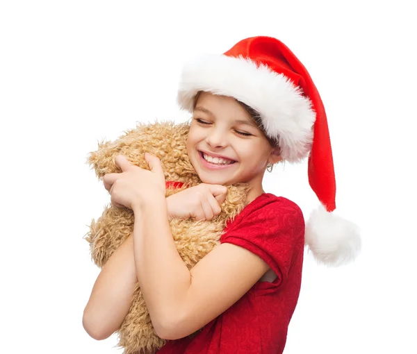 Χαμογελαστό κορίτσι στο santa καπέλο βοηθός με αρκουδάκι — Φωτογραφία Αρχείου