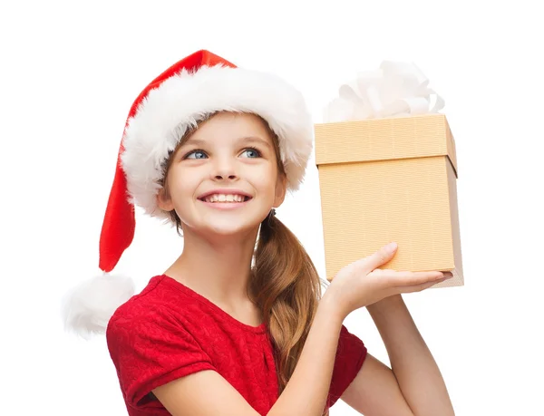 Chica sonriente en sombrero de ayudante de santa con caja de regalo —  Fotos de Stock