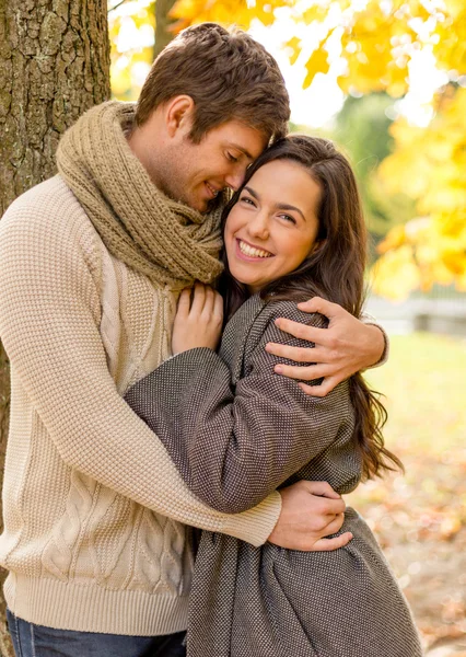 Coppia sorridente che si abbraccia nel parco autunnale — Foto Stock