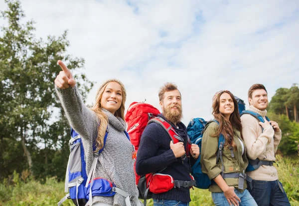 Grupo de amigos sonrientes con mochilas senderismo — Foto de Stock