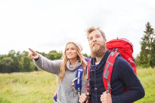 Lachende paar met rugzakken wandelen — Stockfoto